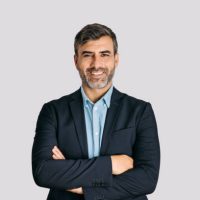 Front view of businessman smiling with arms crossed on white background